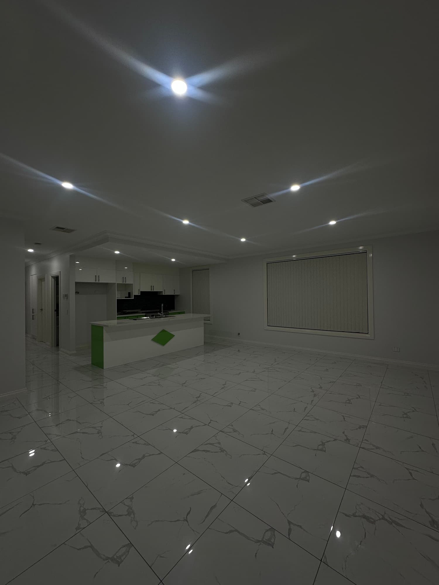 Open-plan kitchen and living area with marble-look flooring